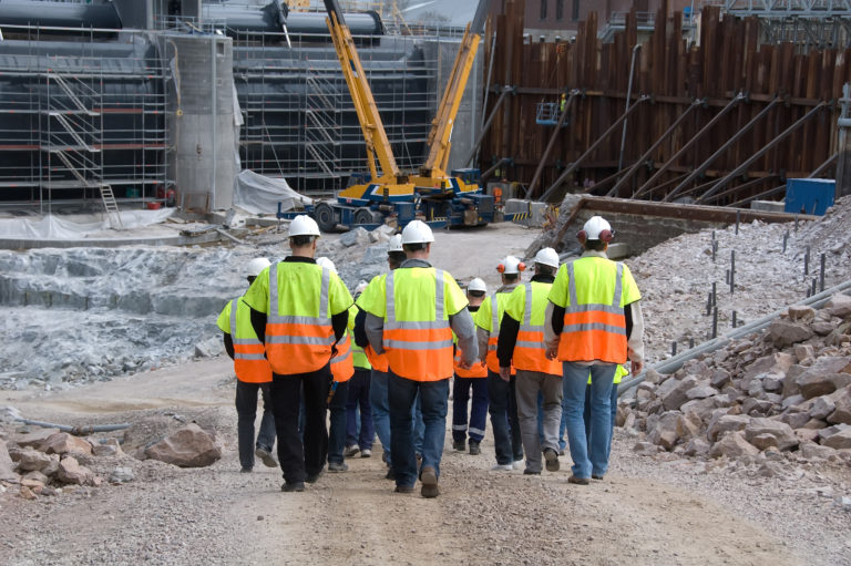Construction workers going to work wearing helmets